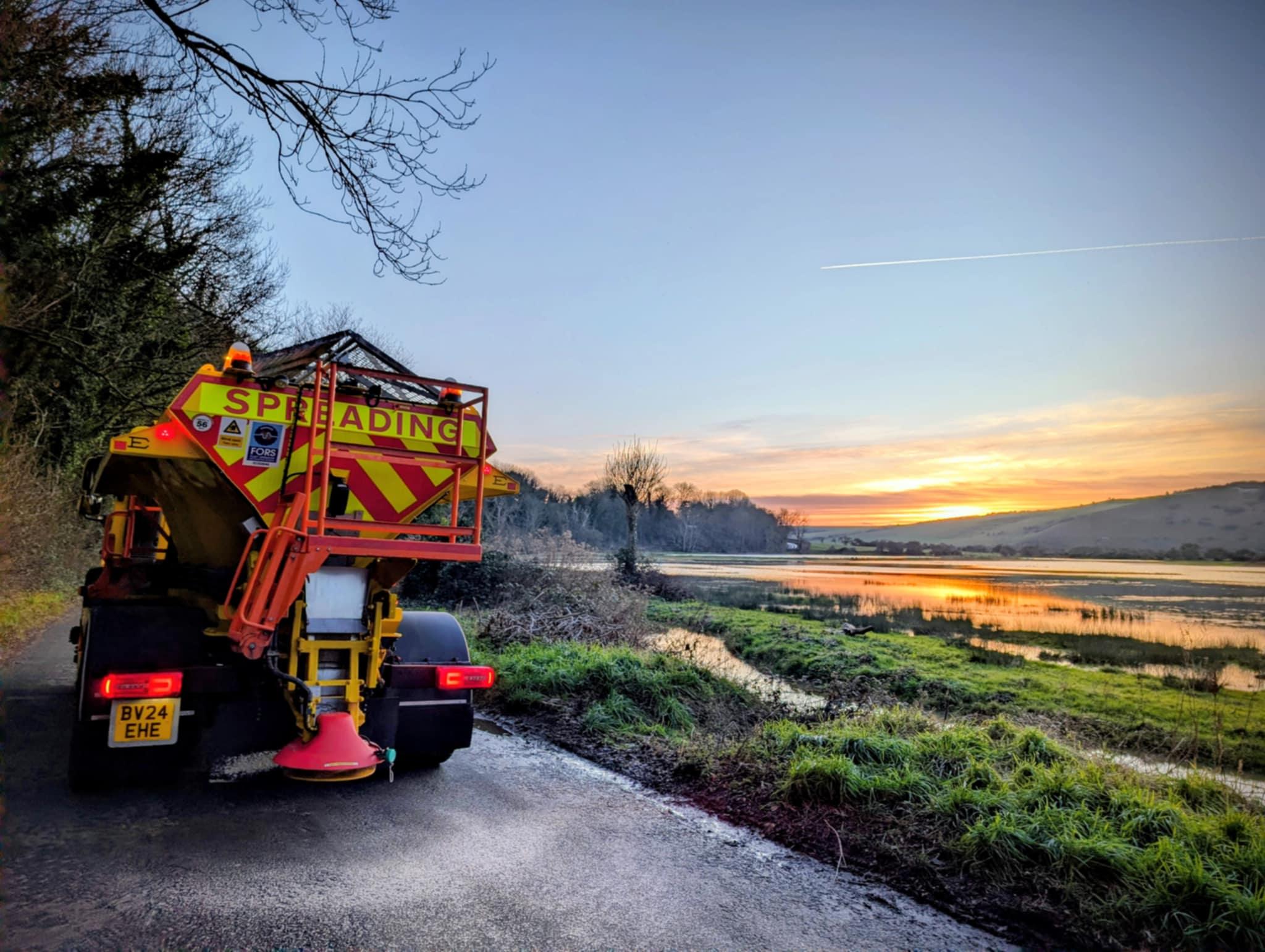 Image of a gritter with a sunset background