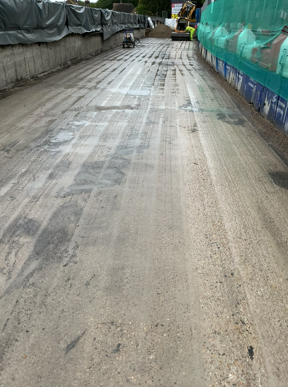 Surface preparation to remove previous waterproofing material and ensure new system bonds to concrete surface